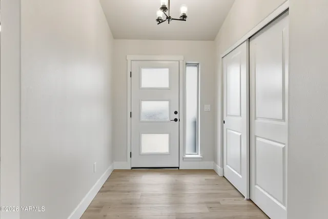 an empty room with wooden floor and mirror
