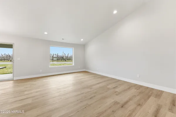 an empty room with wooden floor and window