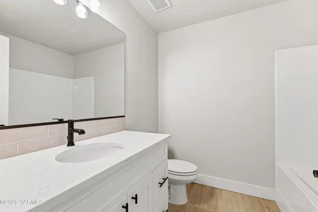 a bathroom with a sink a toilet and mirror