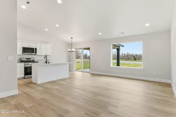 a large kitchen with stainless steel appliances kitchen island a large counter top and a wooden floors