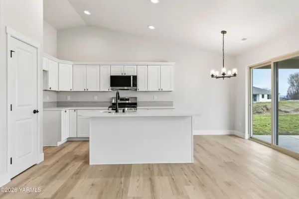 a kitchen with kitchen island a counter top space stainless steel appliances and a window