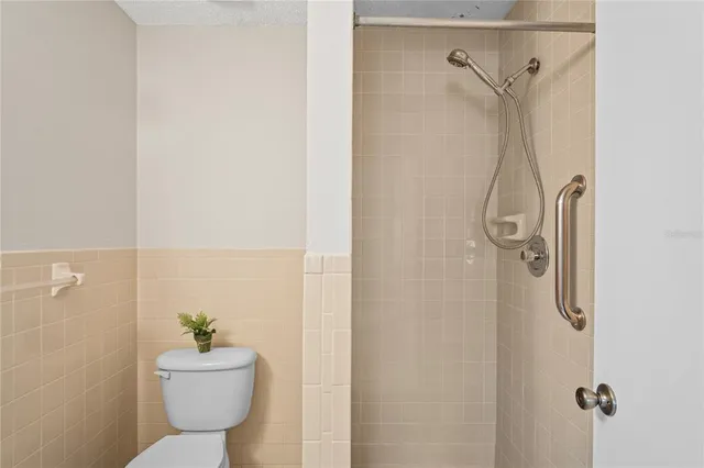 a bathroom with a shower a toilet and a shower