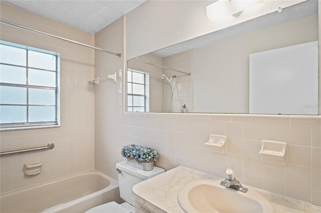 6028 Wilds Drive, Unit 6A New Port Richey, FL 34653 - Photo 21 of 40 a bathroom with a sink a toilet and shower