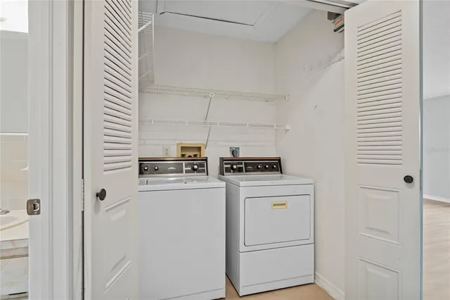 a view of washer and dryer with wooden cabinets