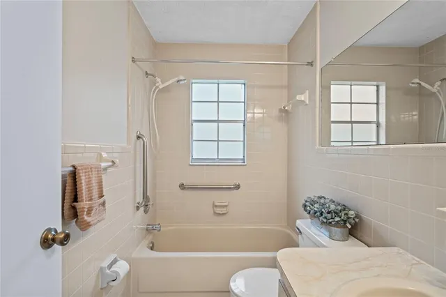 a bathroom with a bathtub shower and toilet