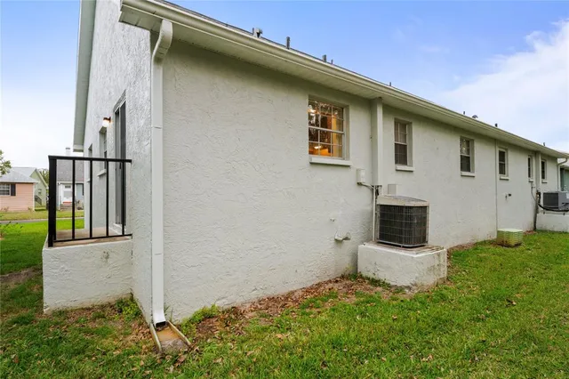 a view of a white house with a yard and potted plants