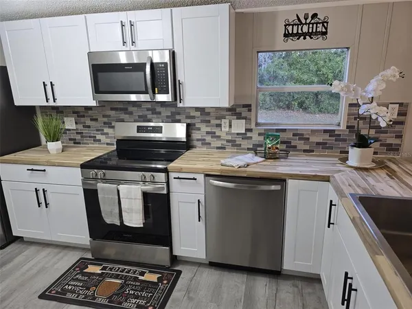 a kitchen with a stove a sink and a microwave