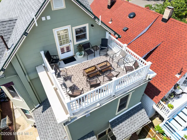 a view of a roof deck with table and chairs with wooden floor and fence