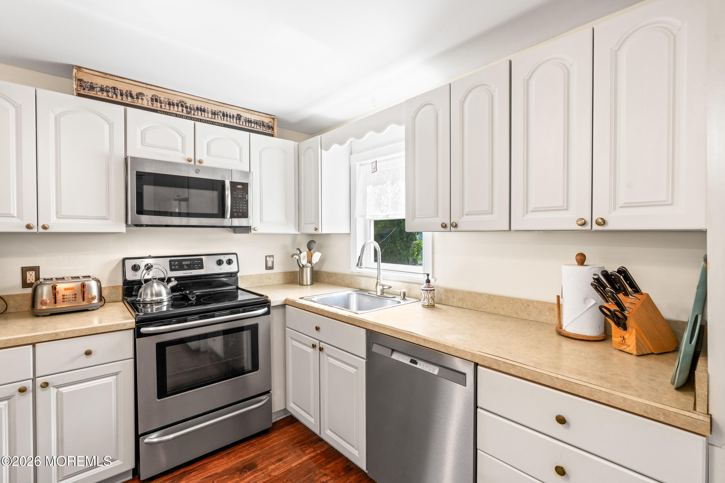 a kitchen with appliances a sink and cabinets