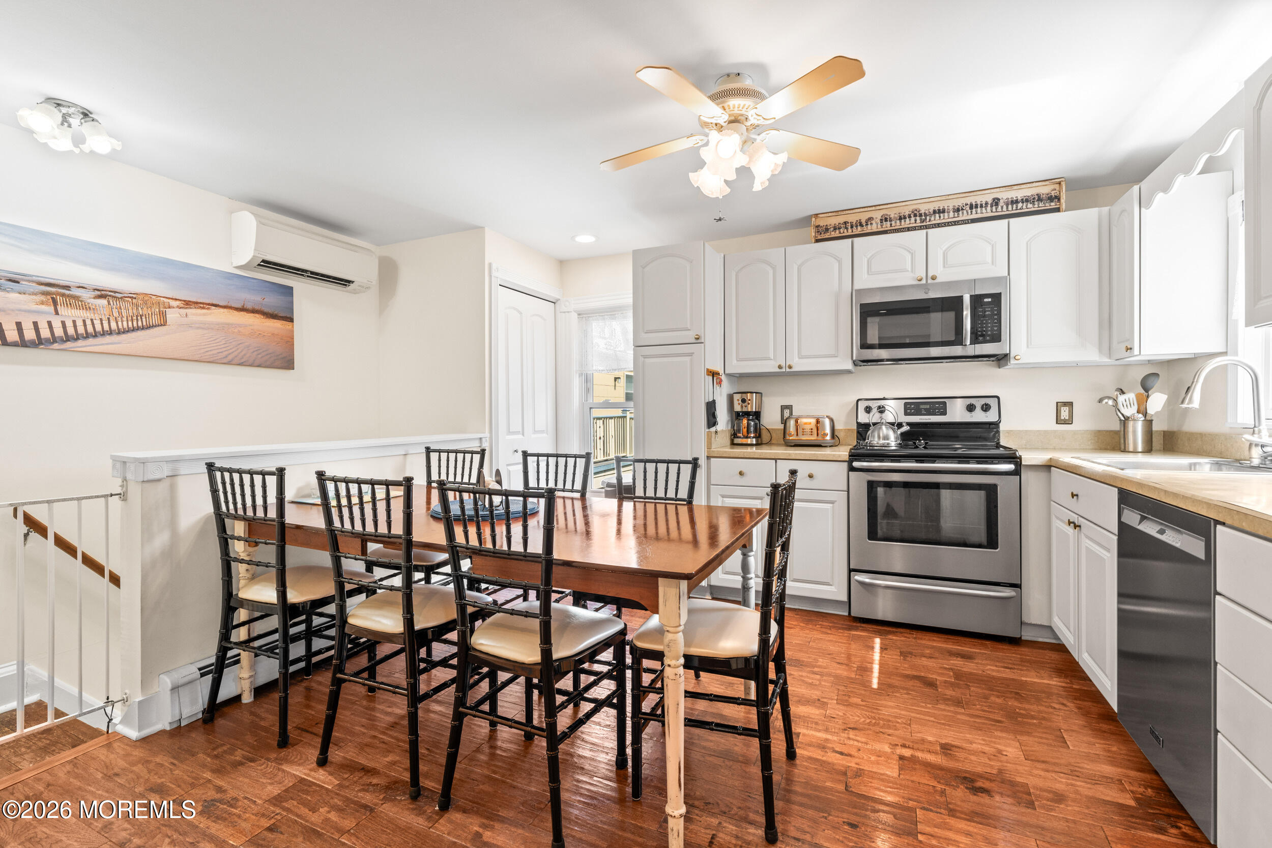 75 Webb Avenue, Unit UPPER WEEKLY Ocean Grove, NJ 07756 - Photo 13 of 41 a kitchen with stainless steel appliances granite countertop a stove a sink a microwave a dining table and chairs with wooden floor