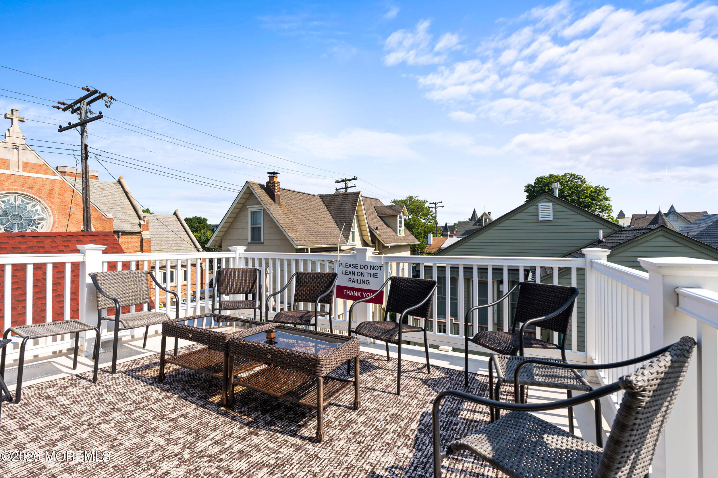 75 Webb Avenue, Unit UPPER WEEKLY Ocean Grove, NJ 07756 - Photo 2 of 41 a view of a roof deck with table and chairs with wooden floor and fence