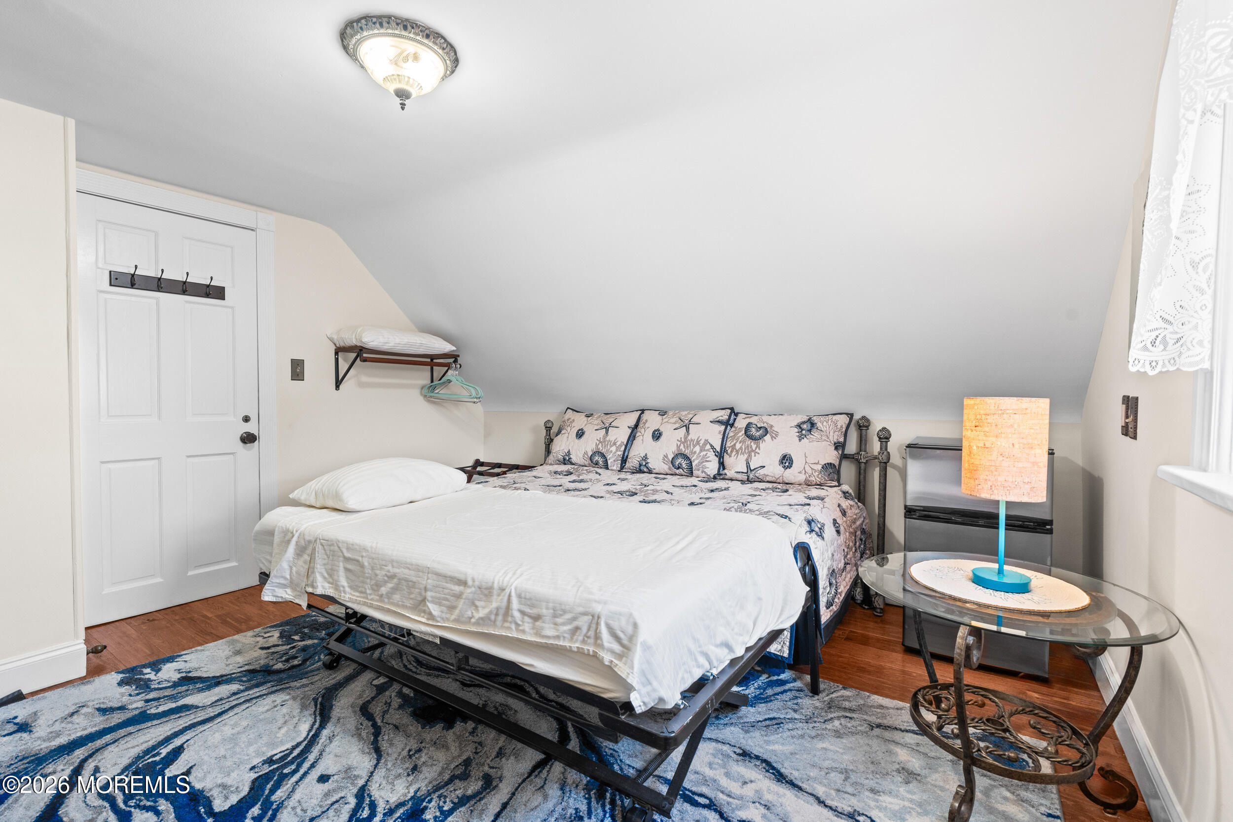 75 Webb Avenue, Unit UPPER WEEKLY Ocean Grove, NJ 07756 - Photo 26 of 41 a bedroom with a bed and a table in it