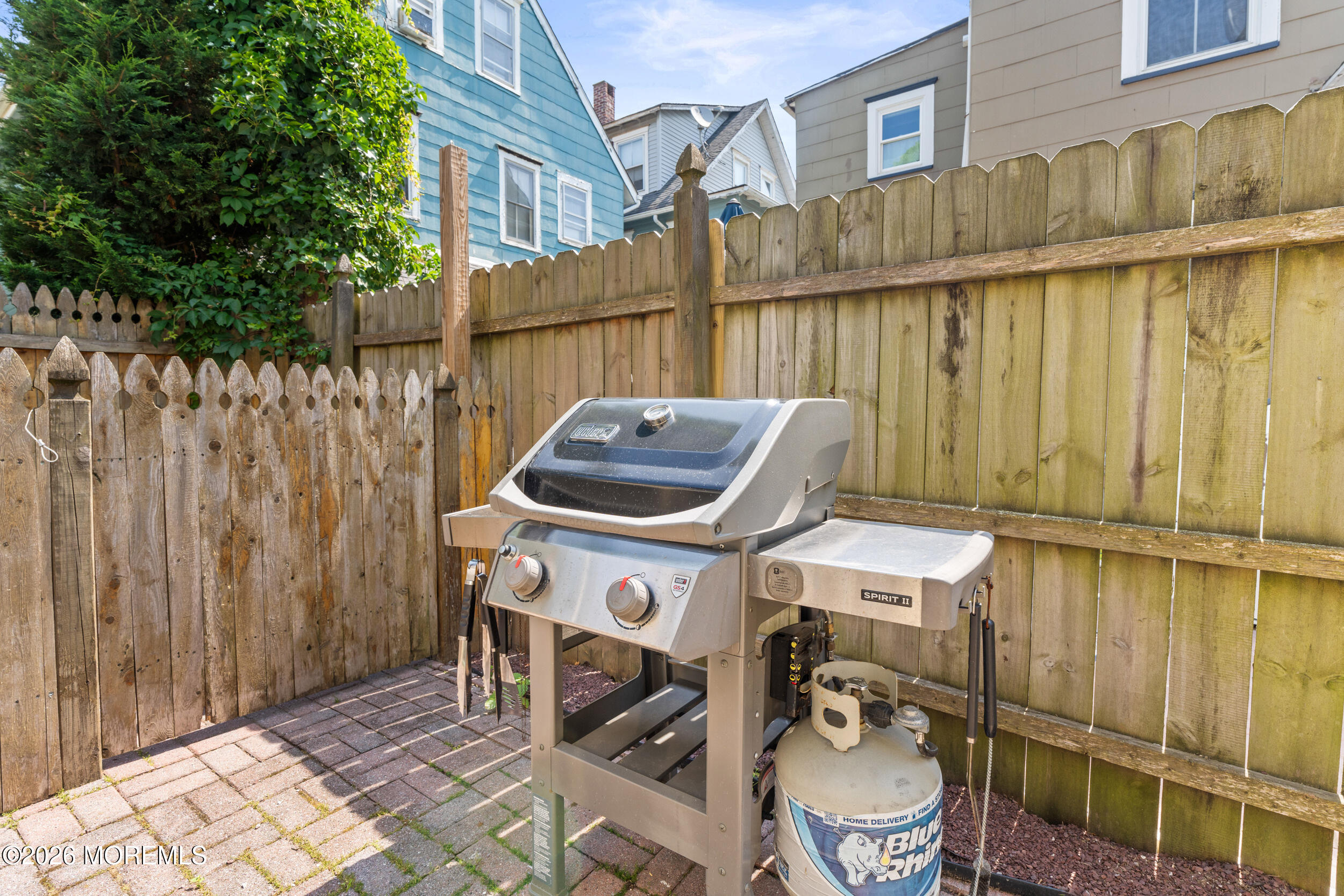 75 Webb Avenue, Unit UPPER WEEKLY Ocean Grove, NJ 07756 - Photo 38 of 41 a view of a patio with table and chairs with wooden fence
