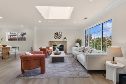 a living room with furniture a fireplace and a floor to ceiling window