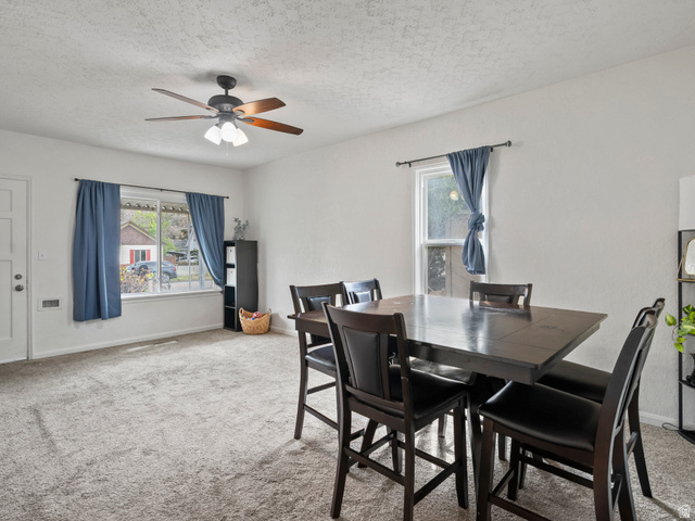 510 Canyon Road Ogden, UT 84404 - Photo 8 of 30 Dining room with light carpet, healthy amount of natural light, a ceiling fan, and a textured ceiling