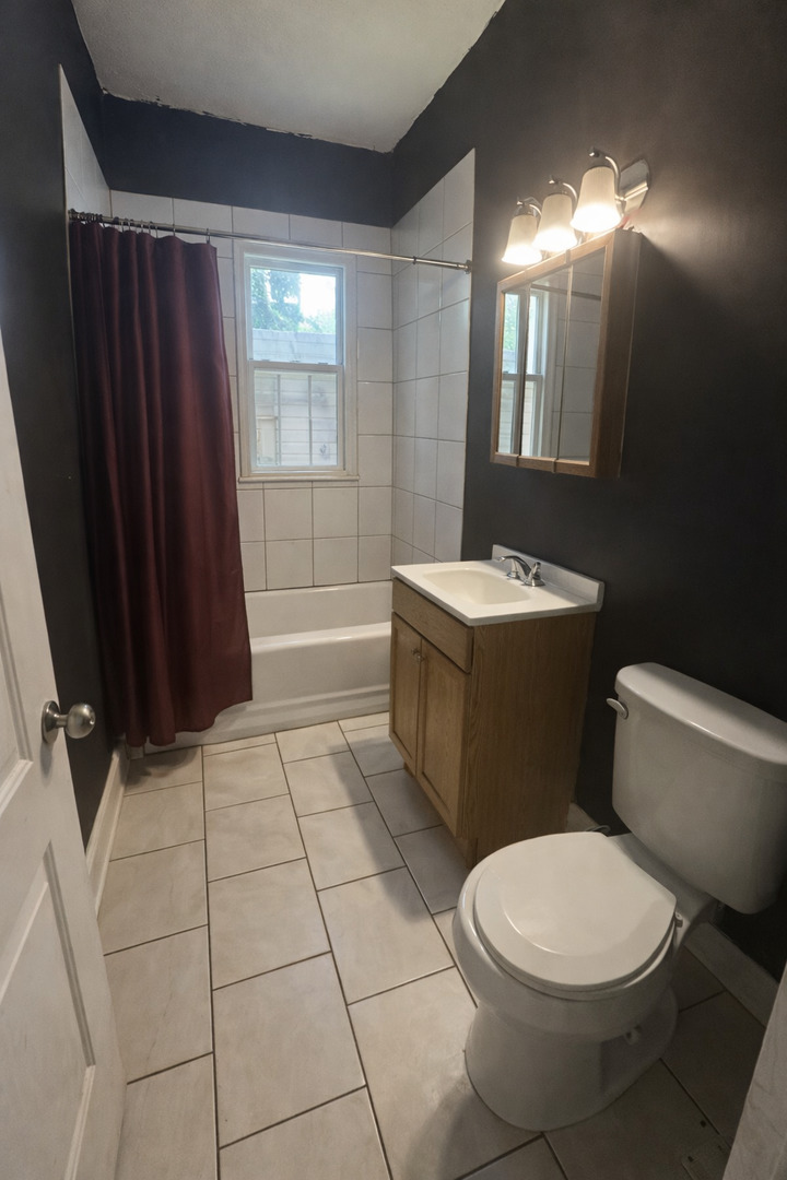5320 South Carpenter Street Chicago, IL 60609 - Photo 5 of 5 a bathroom with a sink a toilet a mirror a vanity and window