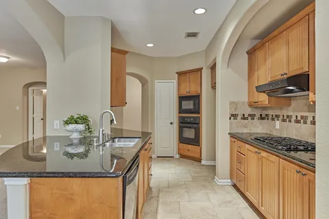 a kitchen with granite countertop a stove and a sink