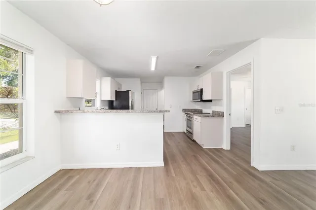 a kitchen with stainless steel appliances granite countertop a refrigerator and a sink