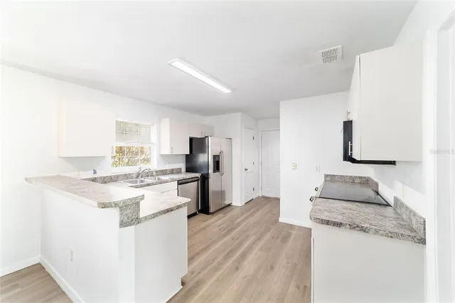 an empty room with wooden floor and a ceiling fan