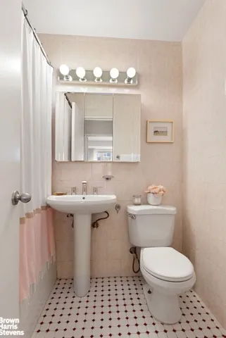 a bathroom with a sink a toilet and mirror