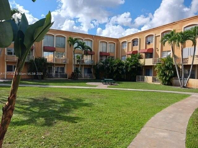 17911 Northwest 68th Avenue, Unit M104 Hialeah, FL 33015 - Photo 1 of 16 a front view of a house with garden