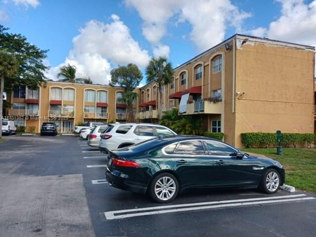 17911 Northwest 68th Avenue, Unit M104 Hialeah, FL 33015 - Photo 14 of 16 a car parked in front of a house