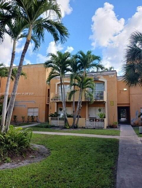 17911 Northwest 68th Avenue, Unit M104 Hialeah, FL 33015 - Photo 2 of 16 a front view of multi story residential apartment building with yard and green space