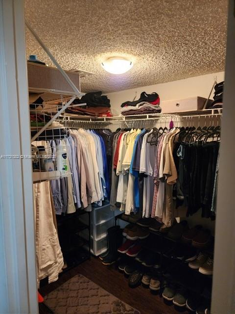 17911 Northwest 68th Avenue, Unit M104 Hialeah, FL 33015 - Photo 5 of 16 a view of walk in closet with clothes and shoes