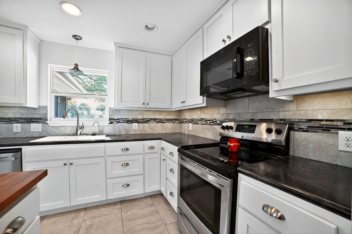 313 Starview Drive Georgetown, TX 78628 - Photo 11 of 38 a kitchen with stainless steel appliances granite countertop white cabinets granite counter tops and a window