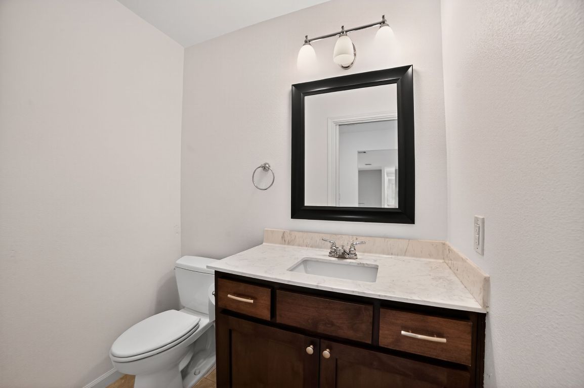 313 Starview Drive Georgetown, TX 78628 - Photo 17 of 38 a bathroom with a toilet a sink and mirror