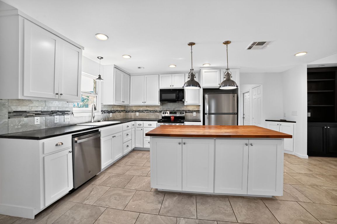 313 Starview Drive Georgetown, TX 78628 - Photo 10 of 38 a kitchen with stainless steel appliances granite countertop a sink and cabinets