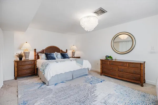 a bedroom with a large bed and a chandelier