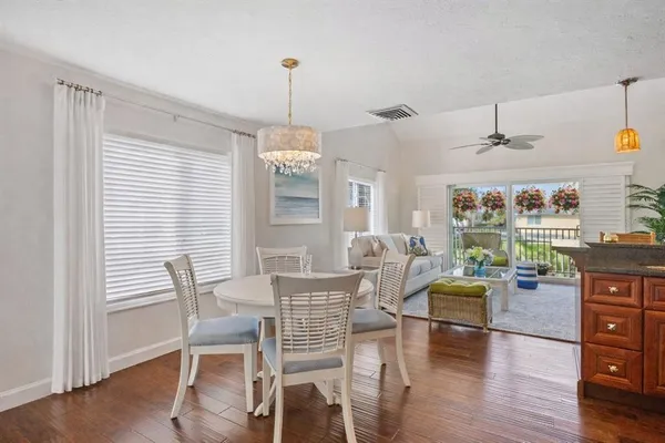 a kitchen with stainless steel appliances granite countertop a stove a sink dishwasher and microwave with wooden floor