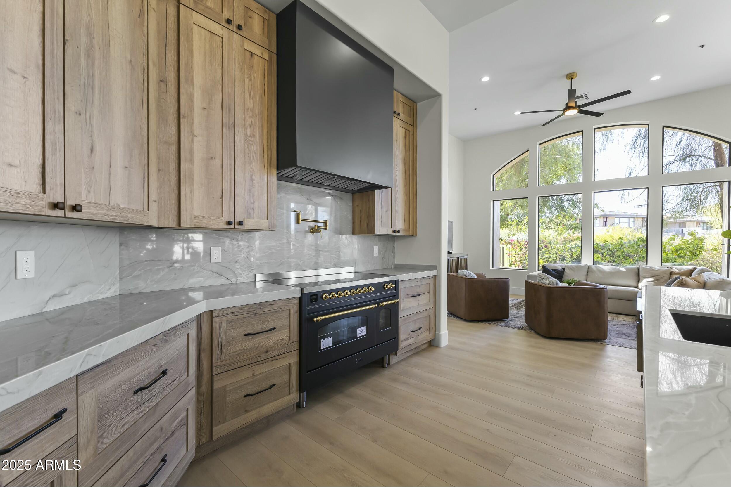 7705 East Doubletree Ranch Road, Unit 21 Scottsdale, AZ 85258 - Photo 11 of 45 a large kitchen with stainless steel appliances granite countertop a sink a stove and a wooden floors