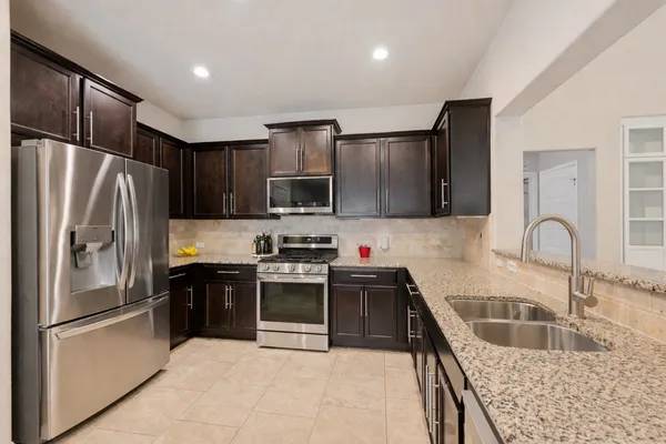 a kitchen with stainless steel appliances granite countertop a refrigerator sink and microwave