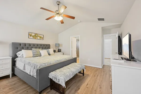 a bedroom with a large bed and a flat tv screen on a dresser