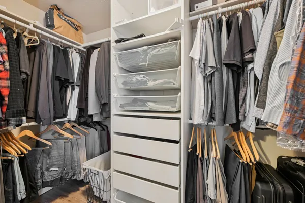 a view of walk in closet with clothes and shoes