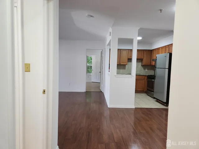a view of a kitchen with a refrigerator and a stove top oven