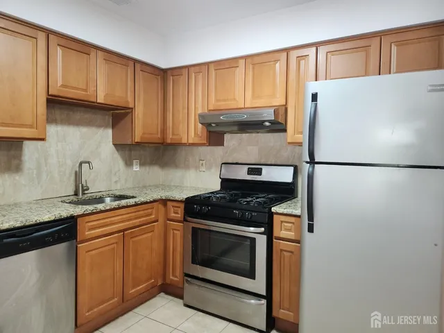 a kitchen with granite countertop white cabinets and white appliances