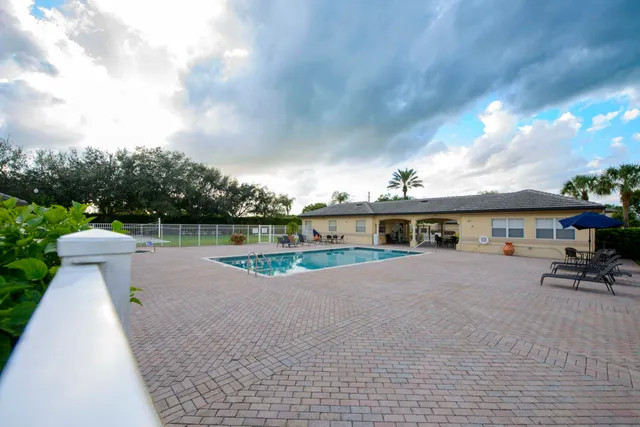 a view of a house with pool and a yard