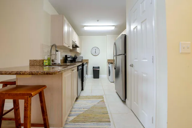 a kitchen with stainless steel appliances granite countertop a refrigerator a stove and a sink