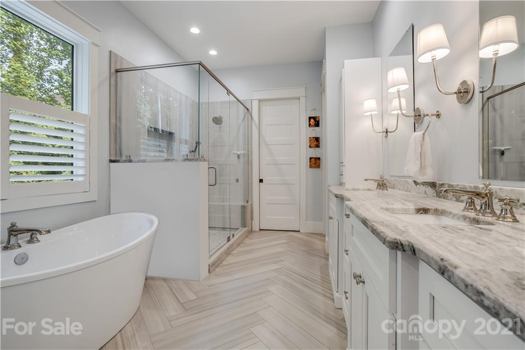 8080 Stillwater Drive Denver, NC 28037 - Photo 16 of 44 a bathroom with a granite countertop sink a mirror a bathtub and shower
