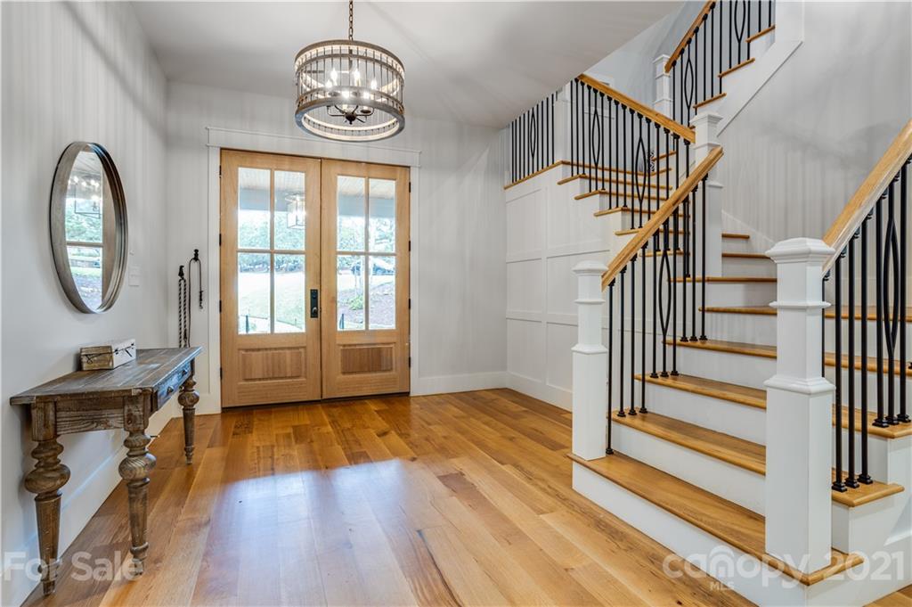 8080 Stillwater Drive Denver, NC 28037 - Photo 3 of 44 a view of a hallway with wooden floor windows a kitchen and stairs