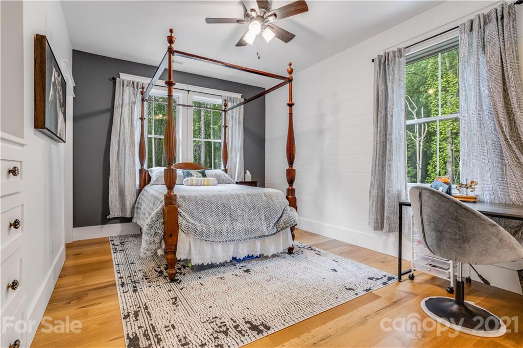 8080 Stillwater Drive Denver, NC 28037 - Photo 23 of 44 a bedroom with a bed and a chandelier