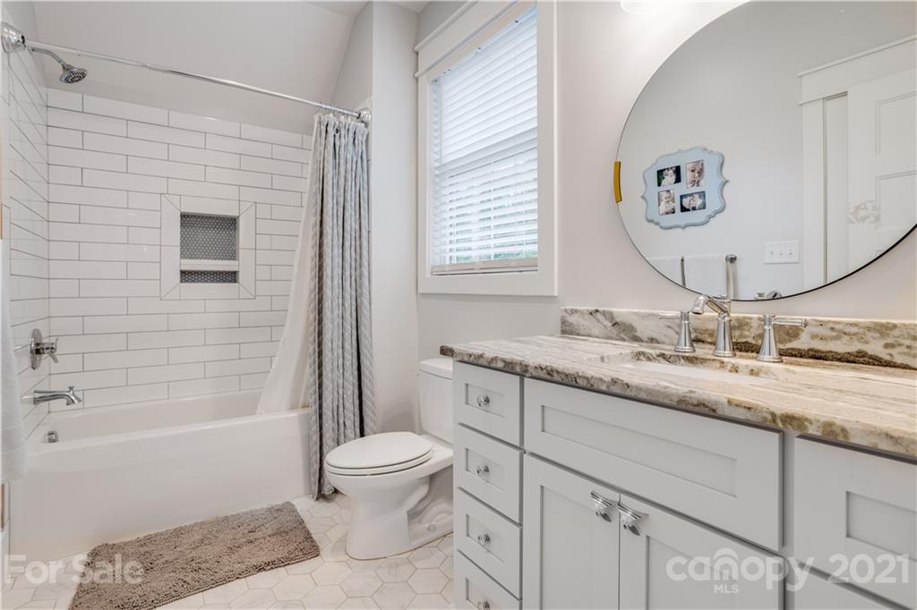 8080 Stillwater Drive Denver, NC 28037 - Photo 30 of 44 a bathroom with a granite countertop sink toilet a mirror and shower