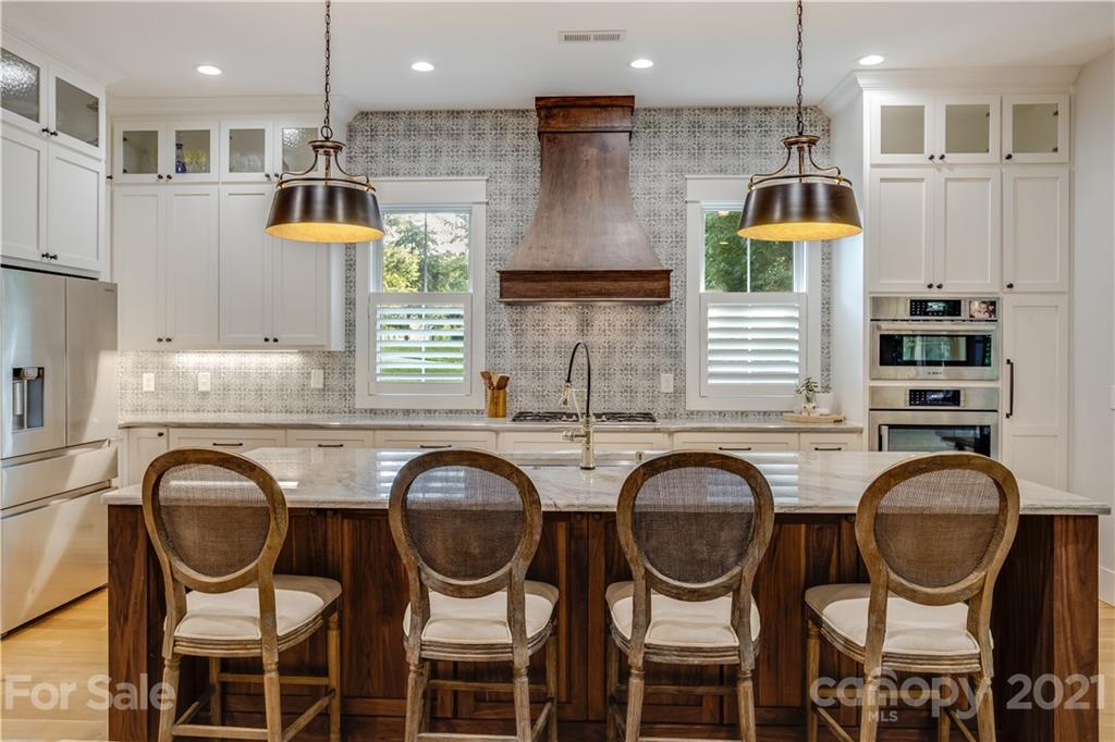 8080 Stillwater Drive Denver, NC 28037 - Photo 4 of 44 a kitchen with stainless steel appliances granite countertop a sink and a stove top oven with wooden floor