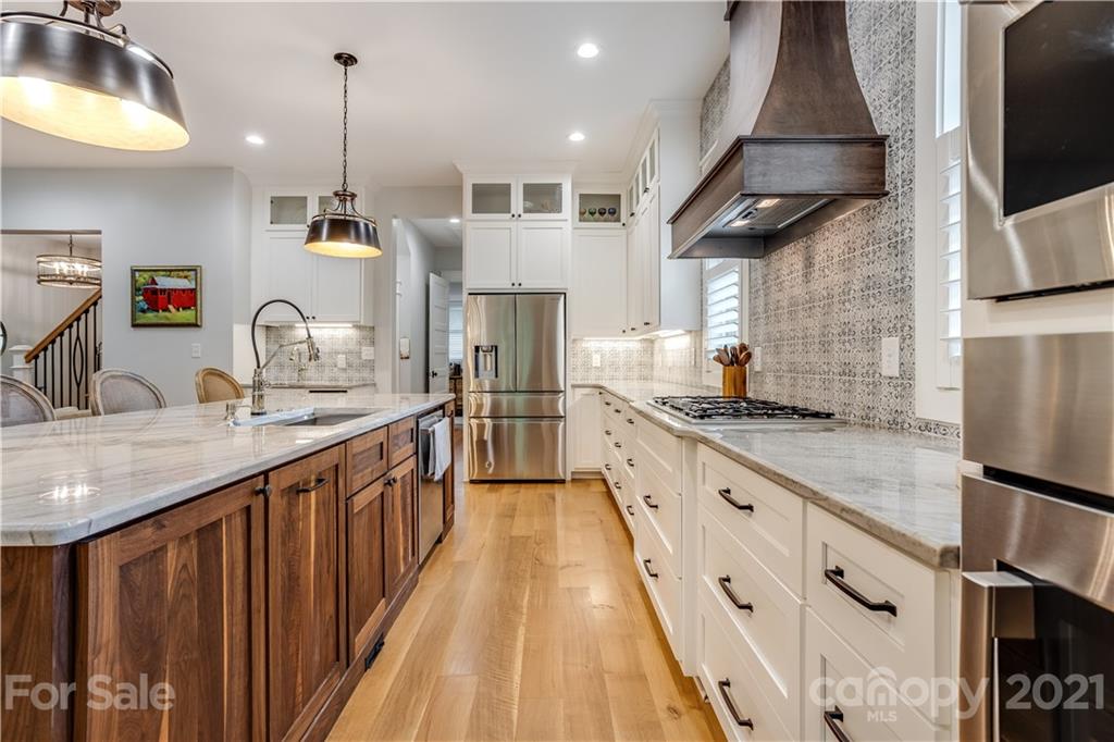 8080 Stillwater Drive Denver, NC 28037 - Photo 8 of 44 a kitchen with stainless steel appliances granite countertop a sink a stove and a wooden floors