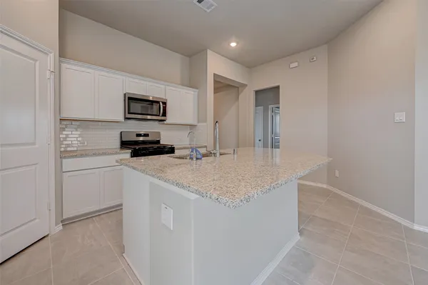 a kitchen with kitchen island a sink stainless steel appliances and cabinets
