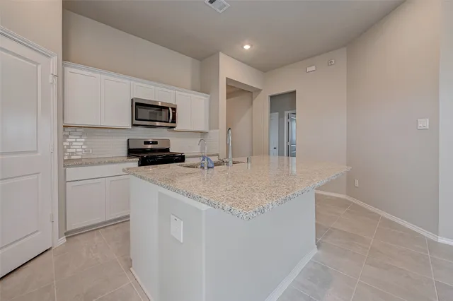 a kitchen with kitchen island a sink stainless steel appliances and cabinets