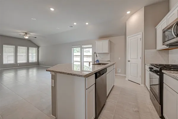 a kitchen with stainless steel appliances granite countertop a stove a sink and a refrigerator